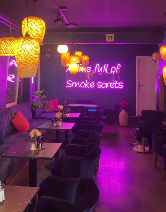 Loungebereich der Nem Bar & Lounge in Göppingen mit Sofas, warmem Licht und Neon-Schriftzug